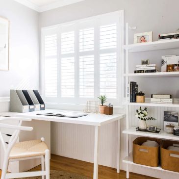 Bright and organized home office with white furniture and wooden accents.