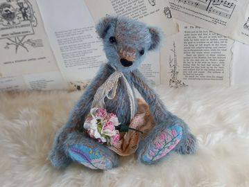 A beautiful blue on tan mohair bear with lace applique and embroidered foot paws.