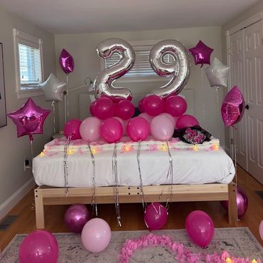birthday balloons showing the number 29 on a decorated bed in a hotel room in boston