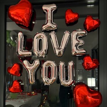 a window decorated with balloons that say i love you at a hotel in boston