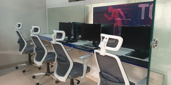 Modern office workspace with ergonomic chairs and computer monitors.