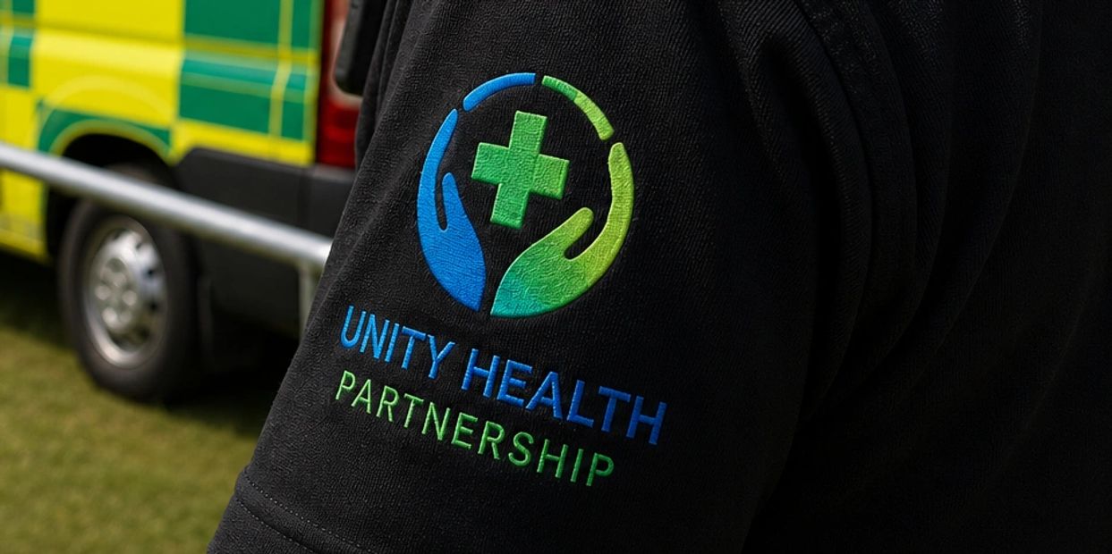 Logo of Unity Health Partnership on a black shirt sleeve.