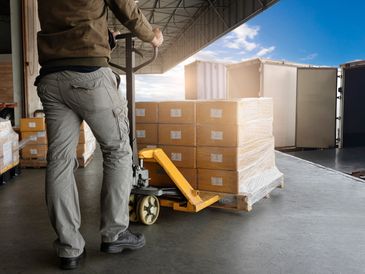 Warehouse Worker Unloading Shipment Boxes into Cargo Container Truck. Cargo Trailer Truck.