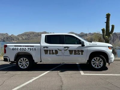 White pickup truck with Wild West handyman advertisement.