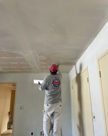 Painter repairing drywall and preparing ceiling for painting in Yorba Linda CA