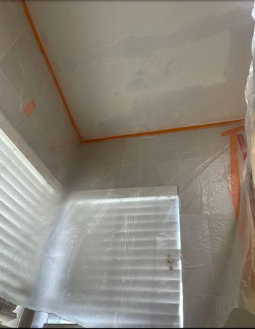 Bathroom ceiling drywall repair with protective coverings before painting
