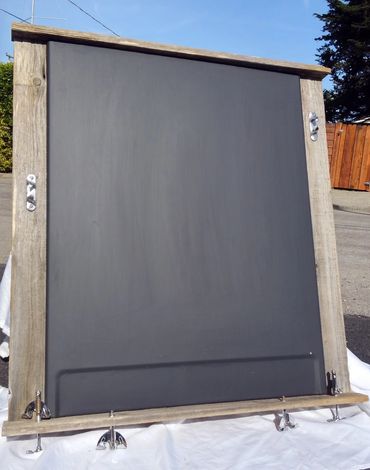 chalkboard from washing machine framed by fence board and boat rope chocks.  Trimmed with drum kit h