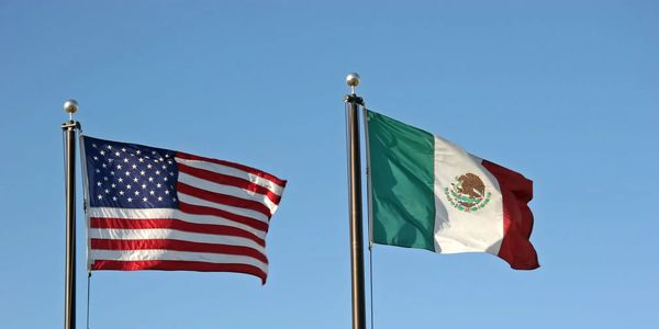 American and Mexican flags waving side by side.