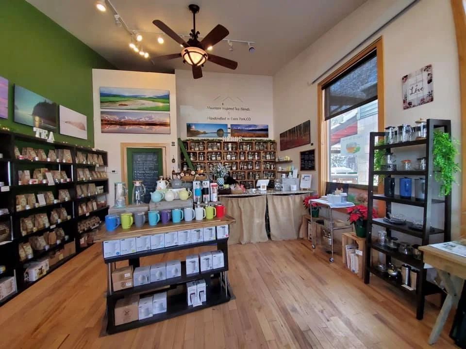 Cozy tea shop with colorful mugs and various tea selections.