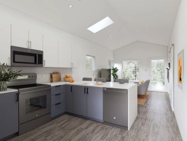 Modern kitchen with gray cabinets, stainless steel appliances, and an open living space.