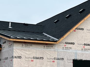 New house under construction with black roofing and homeGUARD wrap.
