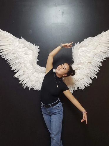 Dancer using recycled wings from another dance production.
