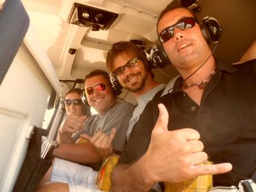 four people posing in a helicopter