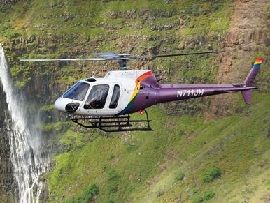 helicopter flying in front of waterfall