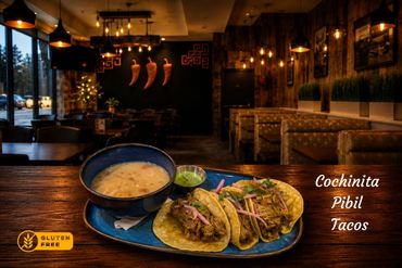 Cochinita Pibil tacos with soup in a cozy restaurant setting.e with citrus and spices until it is fall-apart tender. It is topped with pickled red onions, a sprinkle of fresh cilantro and squeeze of lime. Every bite is vibrant, savoury, and just a little bit tangy - absolutely unforgettable.