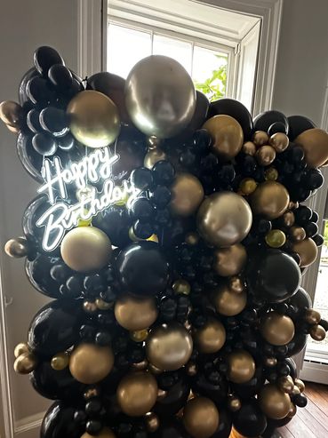 Black and Gold organic balloon wall with happy birthday neon sign to finish it off.