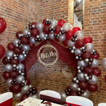 Burgandy and silver with drapes made this balloon hoop for a wedding