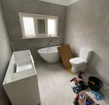 A modern bathroom under renovation with tools and fixtures.