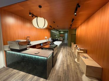 Modern coffee shop interior with wooden walls and marble counter.