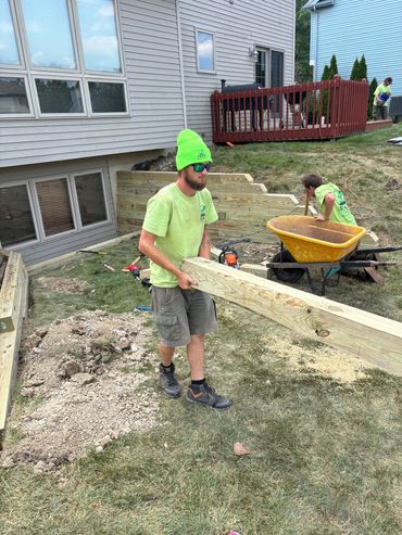 Frain employees working together building a timber retaining wall.