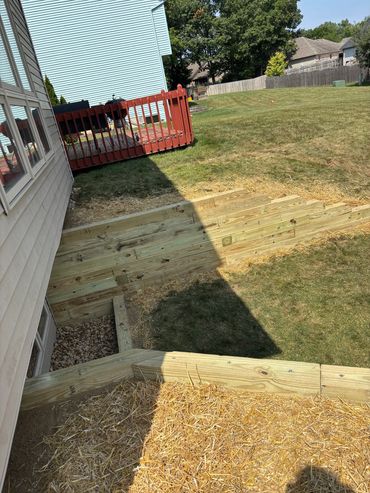 Finishing up timber retaining wall by Frain Landscaping in Fort Wayne, Indiana.