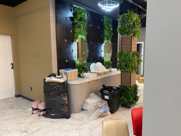 Modern restroom with plant decor and supplies.