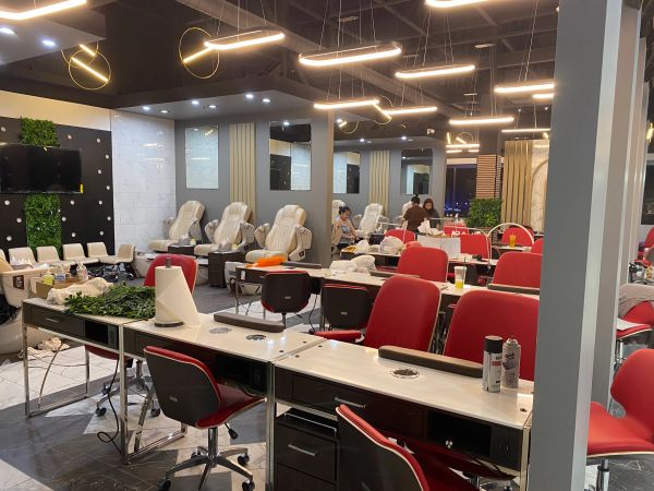 Modern nail salon with red and beige chairs.
