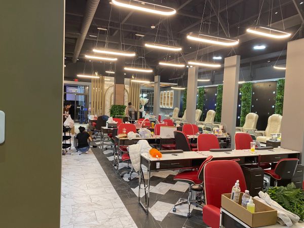 Modern nail salon with red chairs and circular lights.