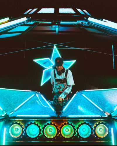 DJ performing with blue neon lights and star decor.