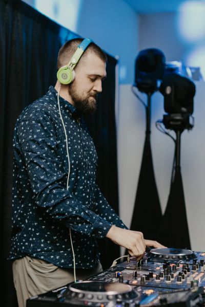 A DJ wearing headphones mixing music.