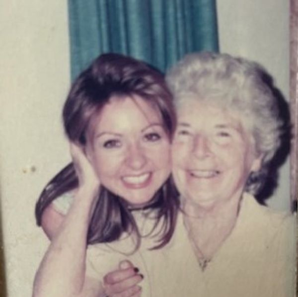 Two women smiling and embracing in a warm, nostalgic photo.