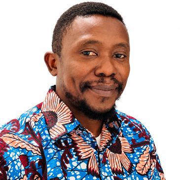 Man in colorful patterned shirt smiling.