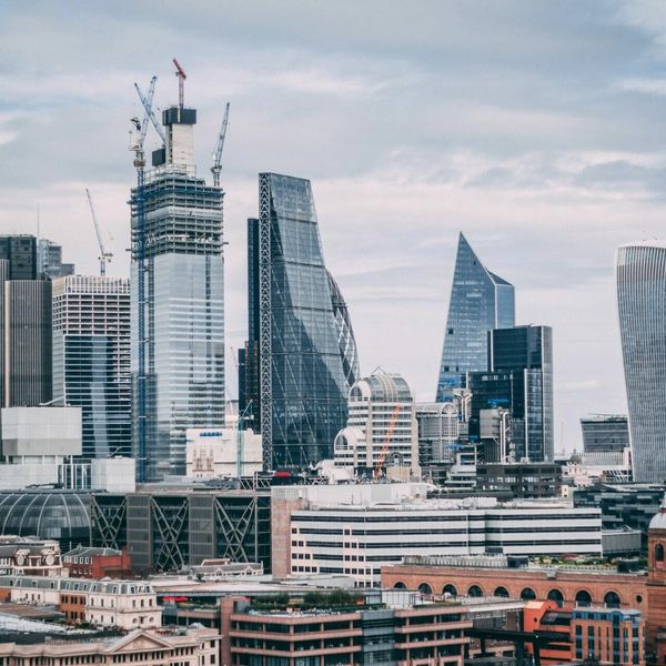 City skyline with modern skyscrapers and cranes.