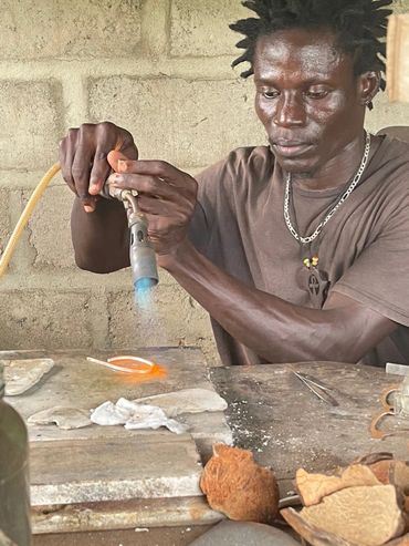 Artist Kofi Essuman works at his jewelery making bench to craft custom sterling silver eyeglass fram