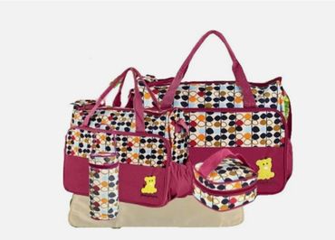 Colorful patterned diaper bags with multiple compartments and a bottle holder.