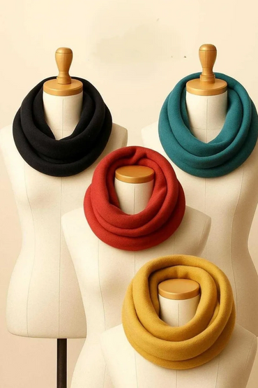 Four mannequins displaying cozy infinity scarves in black, teal, red, and mustard yellow.