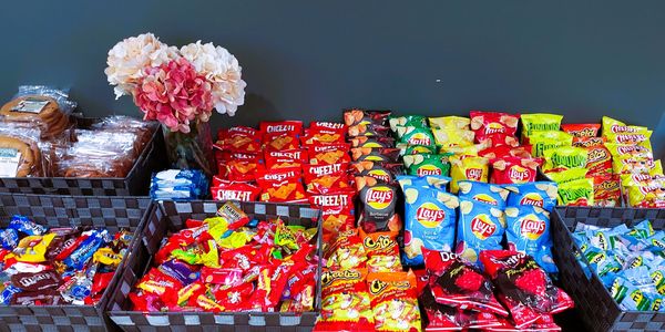 A table neatly organized with various snacks and flowers.
