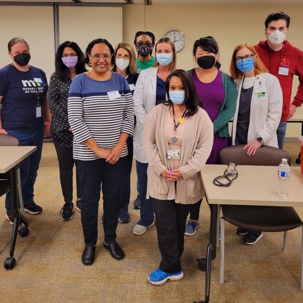 Group of medical professionals wearing masks in a meeting room.
