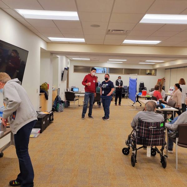 People in a community center setting with some wearing masks.