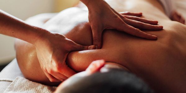 Aroka Thai Spa female therapist is massaging a male client's back with deep tissue massage