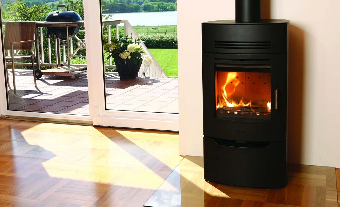 A modern installed woodburner stove glowing in a living room.