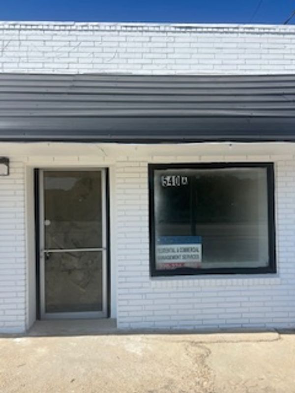 Small brick building with a glass door and window, displaying a sign for counseling services.