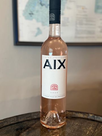 A bottle of 2020 AIX rosé wine from Provence on a wooden surface.