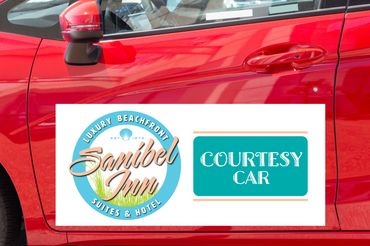 Red car door with a Sanibel Inn courtesy car sign on it.