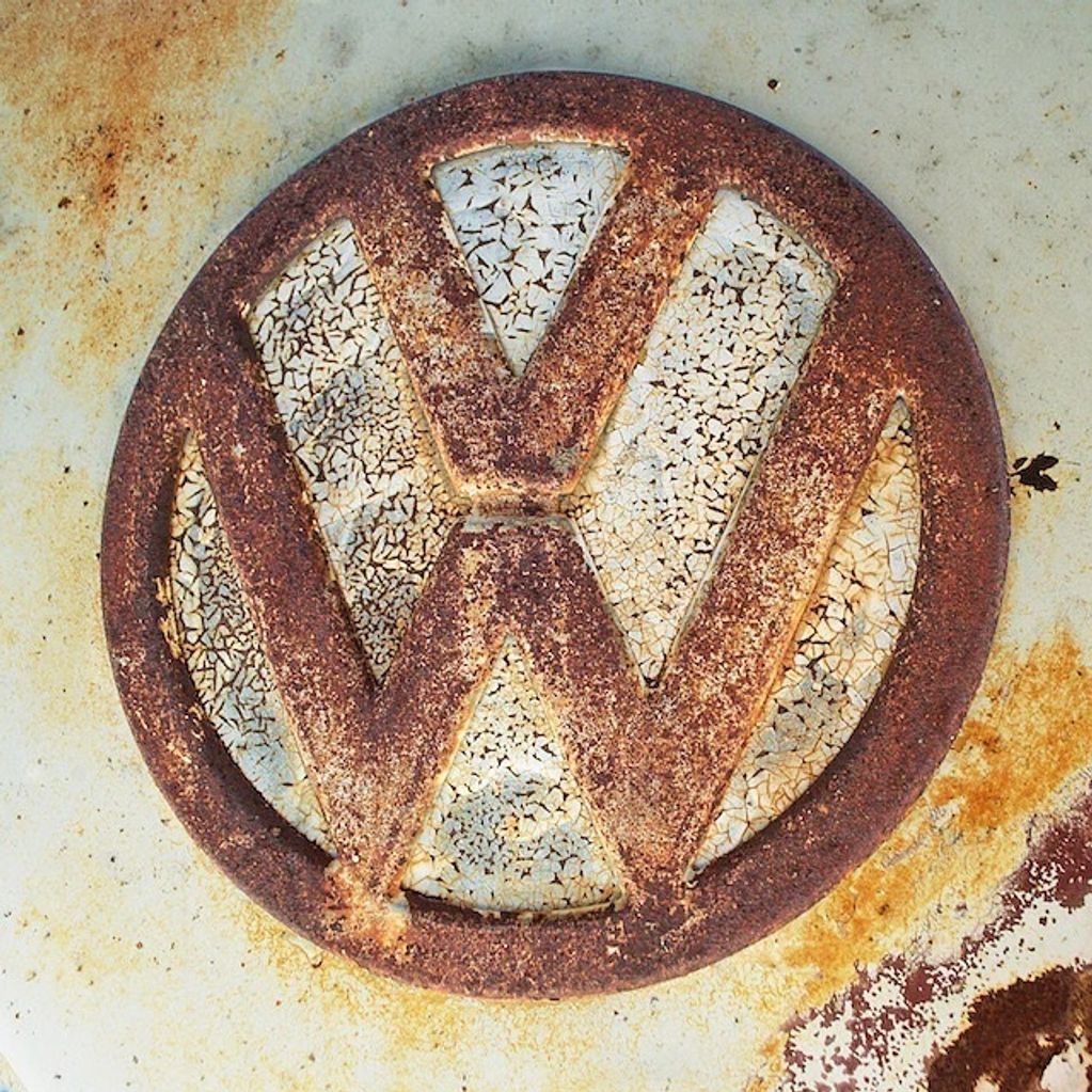Photography close-up on an old 1963 VW Truck. #1 in a series, featuring VW logo, rust, peeling paint