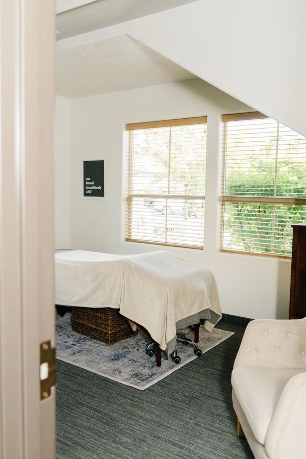 Cozy massage room with natural light and calming decor.