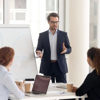 Male business coach speaker in suit give flipchart presentation