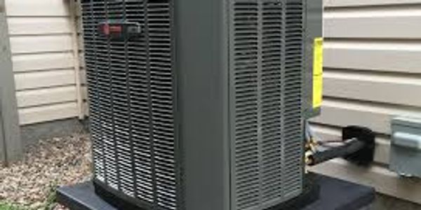 Outdoor air conditioning unit installed beside a house.