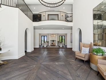 Spacious entryway with elegant wood flooring and modern furnishings.
