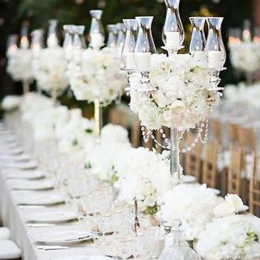 Outside wedding reception with white flowers and glass candelabras